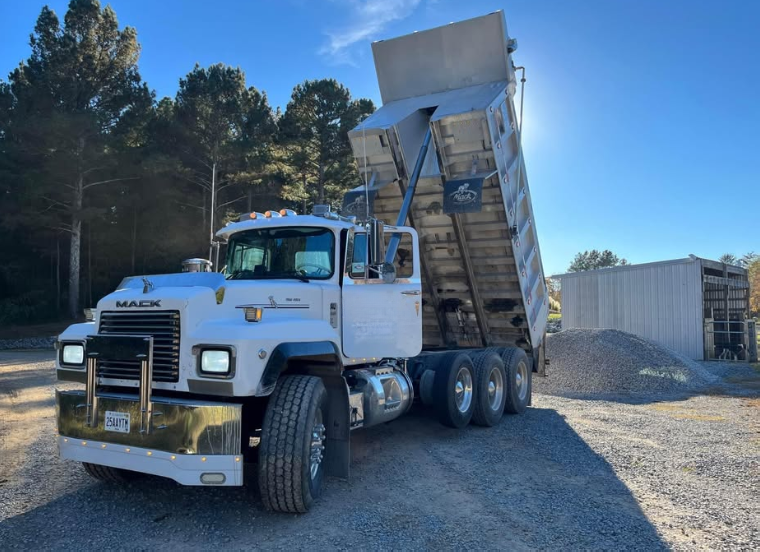 Mack dump truck unloading gravel