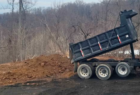 Dump truck dumping topsoil